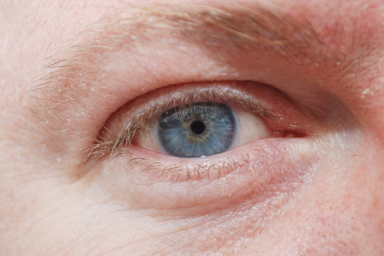 Man's blue eye closeup.