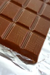 Aromatic milk chocolate bar on foil
