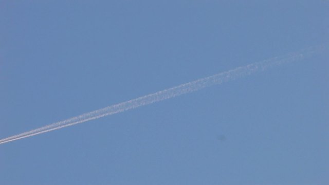 HD aircraft flying in clear skies and leaves trail