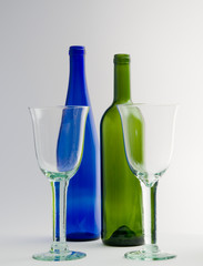 Zwei leere Weingläser und Flaschen