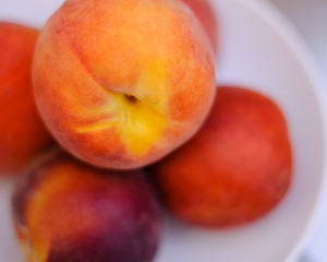 peaches stacked in white bowl