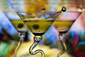 Three colorful martinis in glasses with curved stems