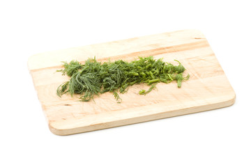 Chopped dill in kitchen wooden board
