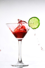 red cocktail with lime on white