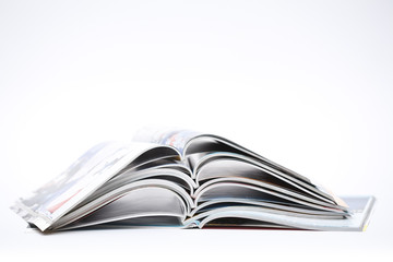 pile of colorful opened magazines on white background