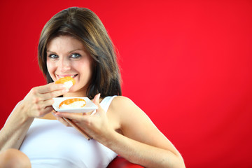femme souriante mangeant des sushis sur fond rouge
