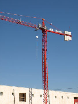Red tower crane on building site