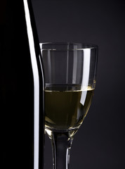 Wine bottle and glass, selective focus, focus on the glass