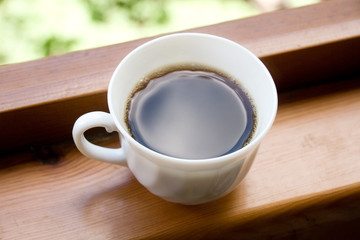Coffee cup with freshly made coffee (on a window sill)