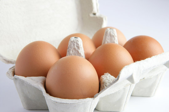 Boîte d'œufs sur fond blanc