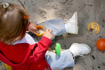 little girl plays in the sand box
