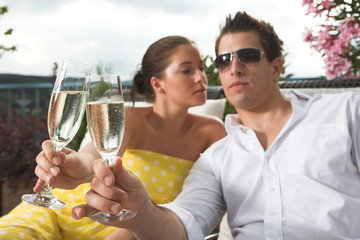 stylish couple having a drink on terrace