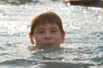 Jugendlicher schwimmt in einem Quellwasser Schwimmbad