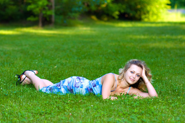 Naklejka na ściany i meble Young woman lying on a green grass