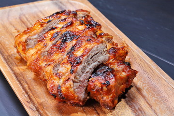 Grilled pork ribs on wooden plate
