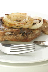 grilled pork rips with onion rings on a plate