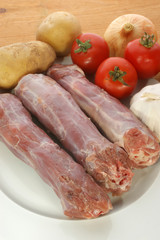 raw turkey neck with vegetables on a plate