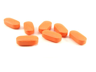Orange pills, prescription drugs on white background