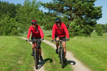 Young woman and man riding mountain bike