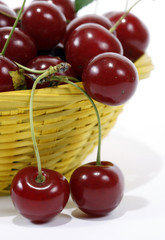 Red cherries in the yellow basket