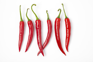 Six red hot chili peppers on a row
