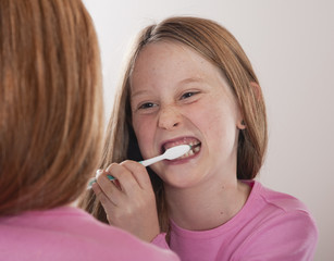 young girl brushing her teeth