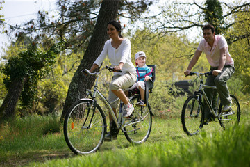 Couple avec un petit garçon faisant du vélo à la campagne