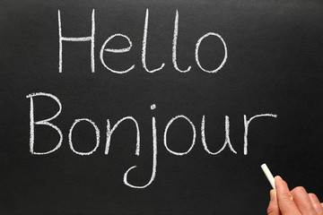 Bonjour, hello in French written on a blackboard. © Sharpshot