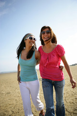 Femmes souriantes se promenant &agrave; la plage