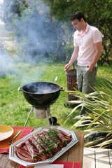 Homme préparant un barbecue dans le jardin