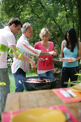 Hommes et femmes cuisant des brochettes