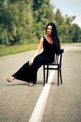 woman sits on a chair on the road