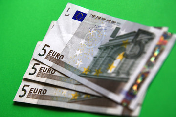 three 5 euro banknote on the green background