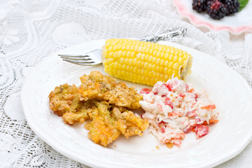 Vegetarian meal of fried blossoms with corn and slaw.