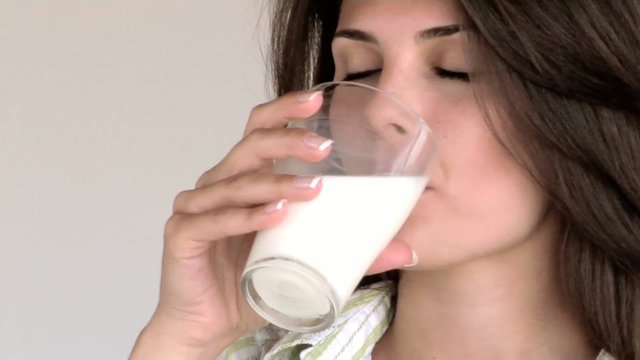 Ragazza beve bicchiere di latte