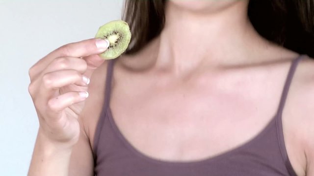 giovane donna mangia kiwi