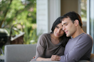 couple assis sur un canapé en terrasse