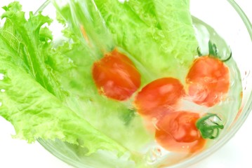 Fresh Baby Tomato with Lettuce Being Rinsed in Glass Bowl.