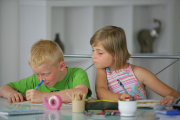 Jeunes enfants assis à un bureau faisant leurs devoirs