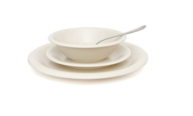Plain beige soup, dinner plates and saucer with spoon isolated