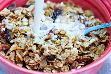 Milk being poured into bowl of muesli. Shallow DOF