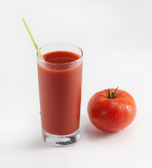 Glass with fresh tomato juice near the tomato