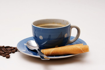 blaue tasse kaffee mit knusperröllchen