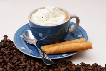 blaue tasse kaffee mit knusperröllchen und Sahne