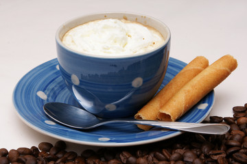 blaue tasse kaffee mit knusperröllchen und Sahne