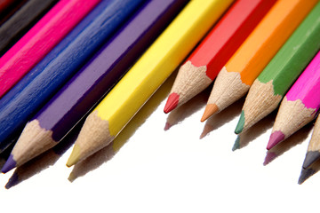 Colored pencils over white background