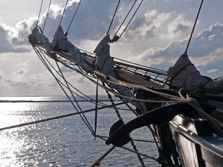 Traditional wood sailboat sailing out