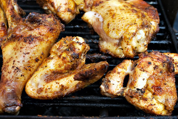 Closeup of chicken meat on barbecue grill with selective focus