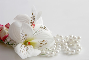 Fototapeta na wymiar pearl necklace and silk flowers