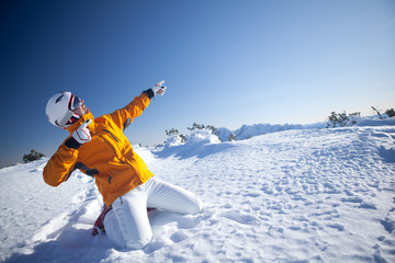 cool guy with ski helmet kneeling in snow